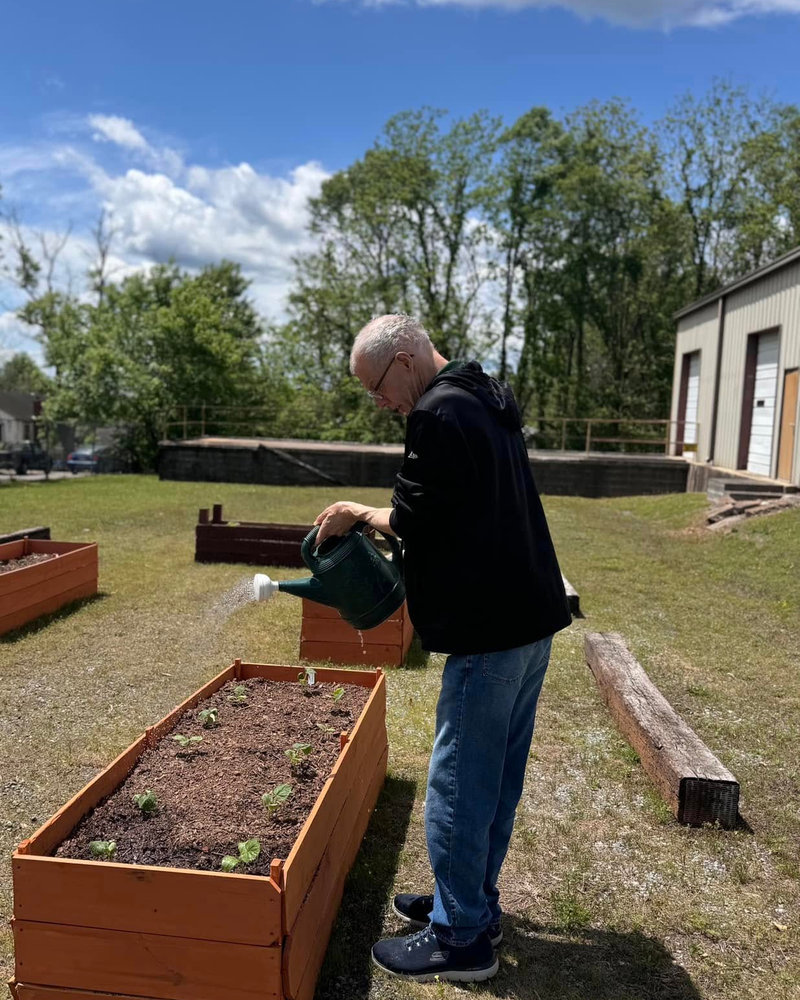 A COI participant tending to the on-site garden